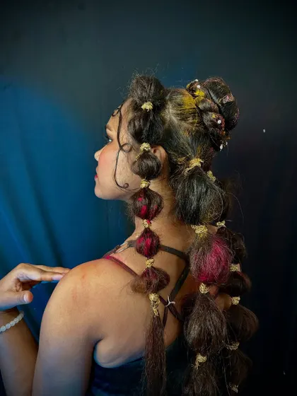 This intricate hairstyle uses multiple bubble ponytails and braids to create a complex, textured look. It's a great example of the advanced, structural hairstyling taught in our courses.