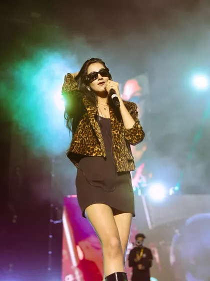 A candid moment of Shahat Gill during her set, with soft, smoky lighting. These unposed shots often reveal the artist's true personality.
