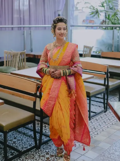 A full-length portrait of a stunning Maharashtrian bride in a vibrant Nauvari saree.