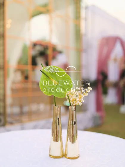 A minimalist floral detail, with two single anthurium stems in sleek golden vases.