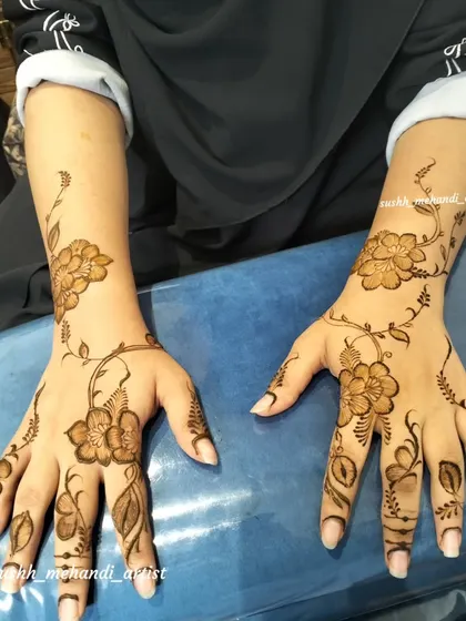 A delicate floral vine design that spreads across both hands. This is a great example of a simple party mehndi.