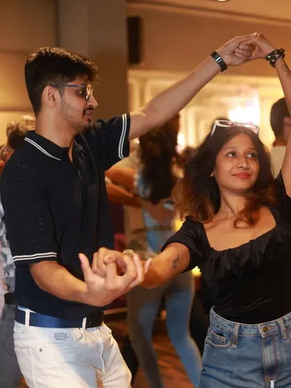 A stylish couple executing a turn with flair. This image shows how our students develop their own personal style on the dance floor.