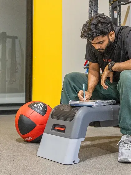 A participant takes a moment to write down notes and reflections during a practical session, a key part of the learning process.