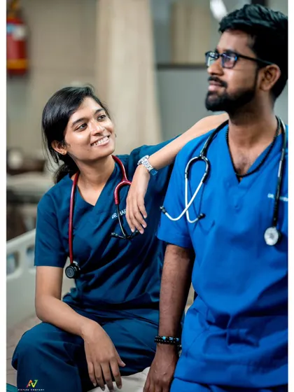 A candid shot of a doctor couple in their scrubs, sharing a lighthearted moment during their unique hospital-themed pre-wedding shoot.