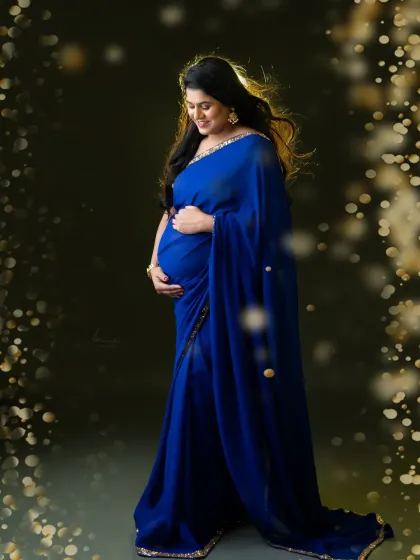 We added a touch of golden sparkle to this photo to create a magical, celebratory feel. The mom-to-be's blue saree glows in this beautiful portrait.