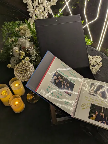 An open Forever Book, set against a backdrop of romantic candles and flowers. This image shows the final product in all its glory, filled with memories and ready to be cherished.