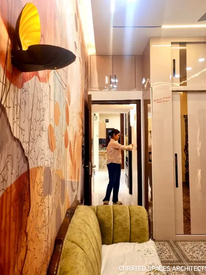This shot highlights the custom wallpaper and unique wall lamp that add a personal and artistic touch to this beautifully designed closet room.