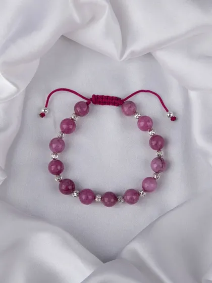 A beaded bracelet with vibrant pink stones and silver accents.