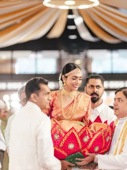 The bride is carried to the mandap in a lotus-shaped basket by her male relatives, a beautiful and unique tradition in some South Indian weddings. She looks like a goddess in this stunning procession.