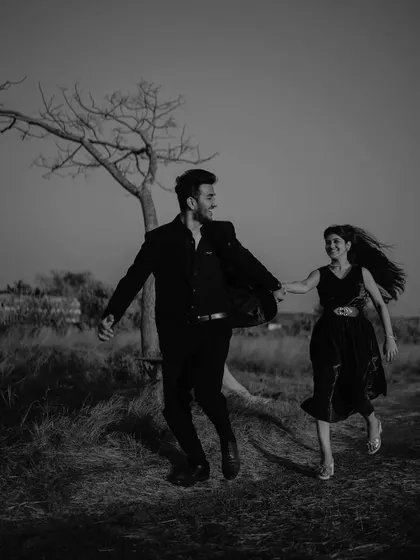 Running hand in hand through the field. This black and white shot is full of movement and freedom, capturing the excitement and joy of starting a new life together.