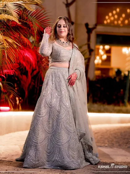 A full-length portrait of the bride in her stunning silver lehenga, captured at an outdoor evening setting.
