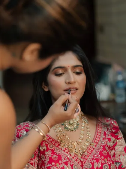 Applying the final touches to the lips, ensuring the color is perfect and long-lasting for the wedding day.