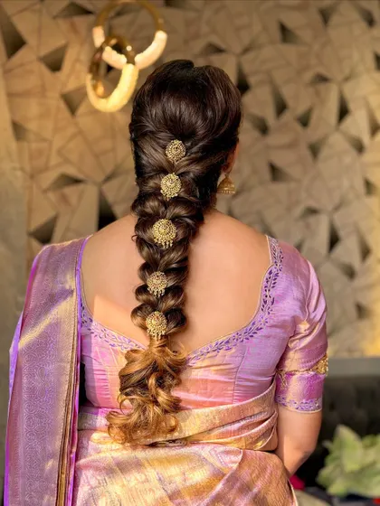 An intricate traditional South Indian braid, adorned with classic gold hair ornaments called 'Jadanagam'.