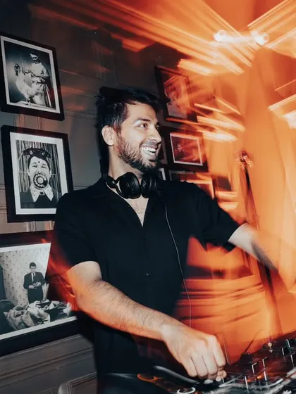 The DJ smiling, feeling the energy from the crowd. It's a two-way street.