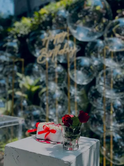 A close-up of the cake and flowers against the bubble backdrop. The clear bubbles and gold frame create a light and airy feel.