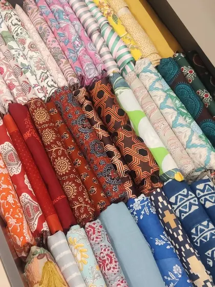 File-folding clothes, like these colorful dupattas and scarves, into a drawer makes every single item visible. This technique saves space and lets you see your entire collection at a glance.