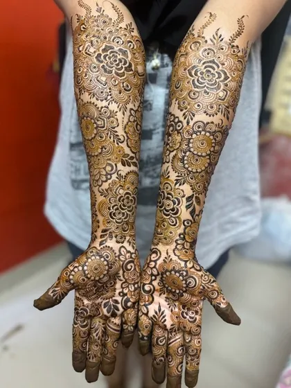 A gorgeous designer pattern for a bride. The repeating circular floral motifs create a mesmerizing effect that covers the hands from fingertips to forearm.