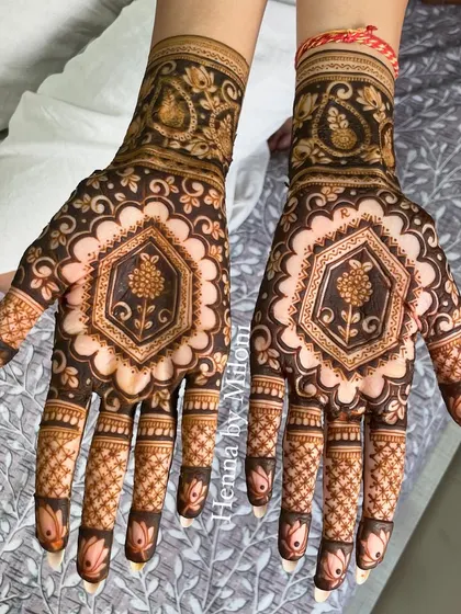 A symmetrical bridal design with a central floral hexagon on the palm, surrounded by delicate details and paisley motifs on the wrist.