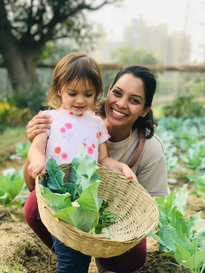 A mother and daughter pose with their basket of freshly picked greens. It's a wonderful bonding activity and a great way to spend quality time together.