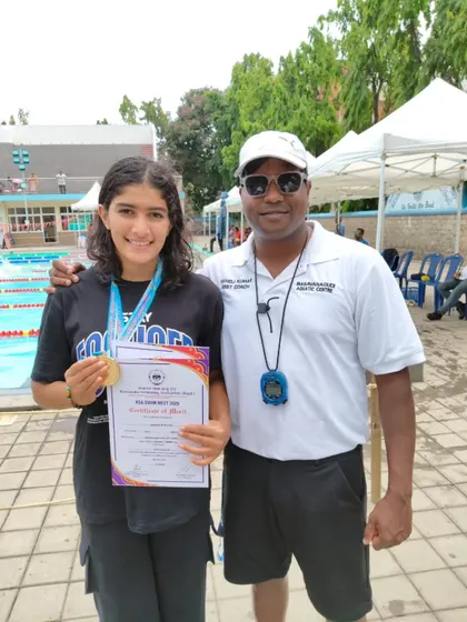 Rianna Dhriti Fernandes with her coach and medal.