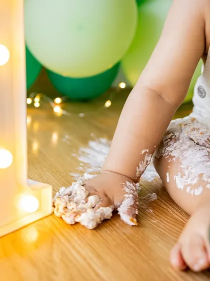 A close-up on the little details, like a frosting-covered hand next to a light-up "1" prop. These elements help tell the story of the big day.