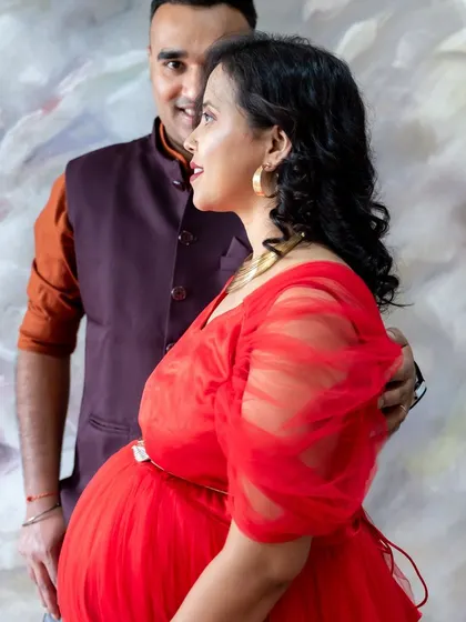 A candid and happy moment between a couple during their studio maternity session.