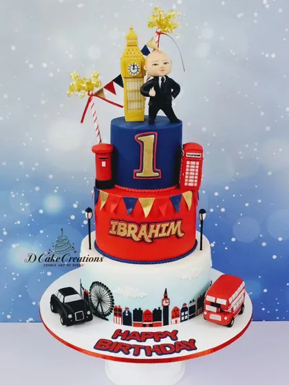Another take on the London theme for a first birthday. This three-tier cake features a "Boss Baby" topper, a red telephone booth, Big Ben, and a classic London bus.
