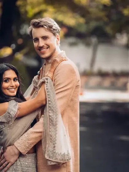 A joyful portrait of a multicultural couple, blending Indian and Western styles with elegance.
