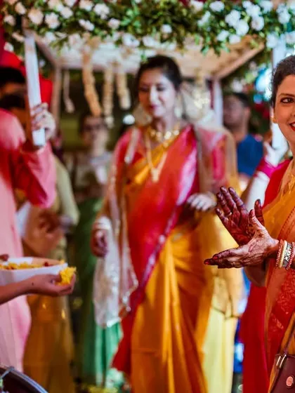 The mother of the bride, her hands open in a gesture of welcome and blessing, as she watches her daughter's bridal entry.