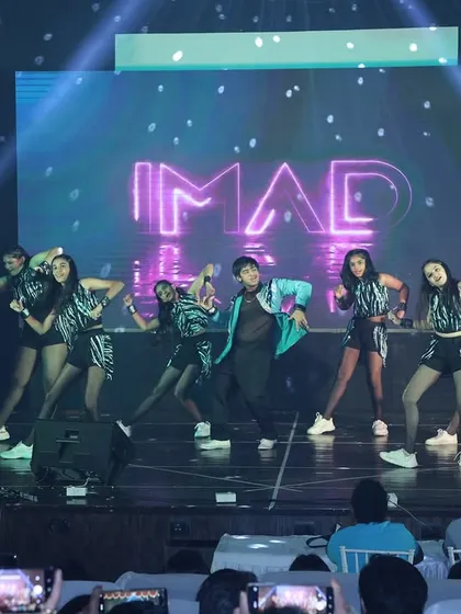 The stage lights catch our Bollyhop dancers in a high-energy pose, showing the professional production quality of our annual show.
