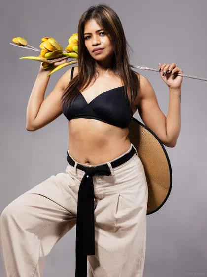 A full-body shot of the model with a flower prop, showing a confident and stylish pose.