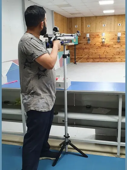 A shooter using a stand to support his rifle, a common practice for sighting and making adjustments. We teach all aspects of equipment handling.