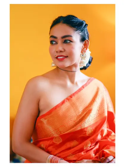 A joyful portrait from the same series, capturing a bright smile and the rich colors of the saree.