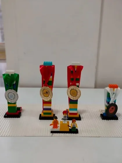 Students get creative by building their own trophies and medals out of LEGOs after an internal competition. This fun activity celebrates participation and achievement for everyone.
