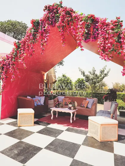 A vibrant pink cabana with a checkered floor offers a fun and stylish seating area for guests.