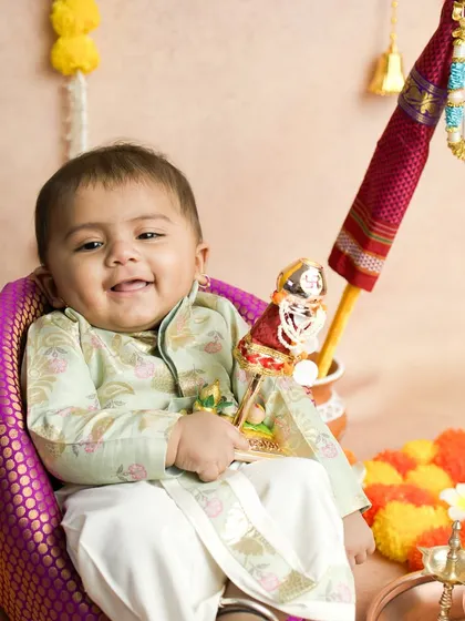 This little one is holding a miniature Gudi, a playful addition to the festive shoot. His happy expression perfectly captures the spirit of the new year.