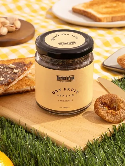 A charming picnic setup for The Food of God's Dry Fruit Spread. We used artificial grass, a gingham cloth, and toast to create a wholesome, natural, and appetizing scene.