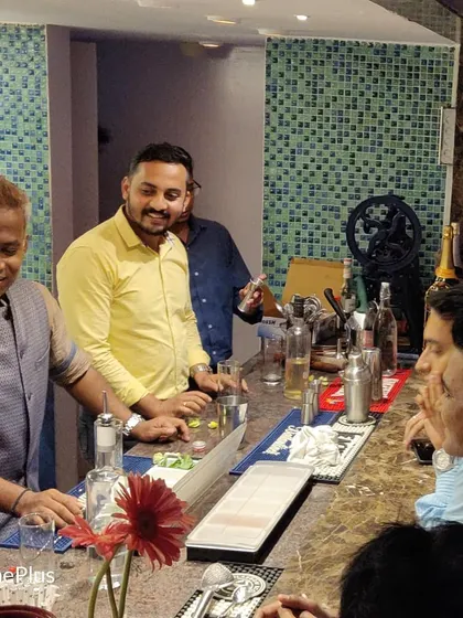 A great view of a hands-on session where everyone is gathered around the bar, learning and interacting in a lively, social setting.