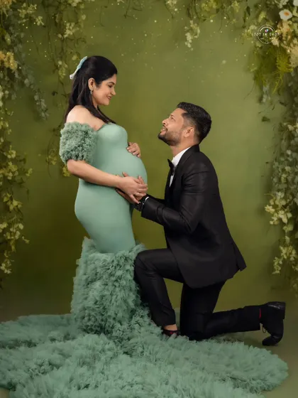 A classic romantic pose, with the dad-to-be on one knee looking up lovingly at his partner.