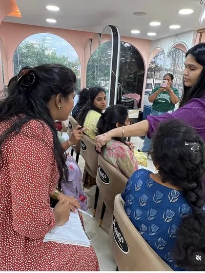 A student gets guidance on hair styling during a practice session.