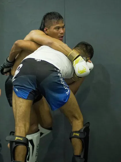 A fighter works for a takedown against the cage wall during sparring. We simulate real fight scenarios to prepare our athletes for any situation.