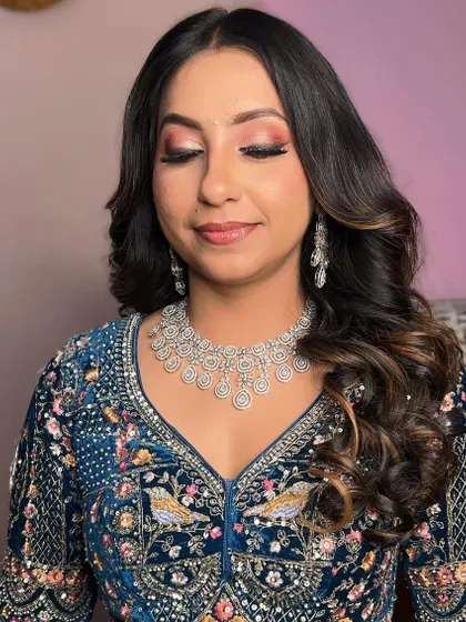 A subtle glam look for an engagement party. The soft, shimmery eye makeup and gentle waves in her hair create an elegant and sophisticated appearance.