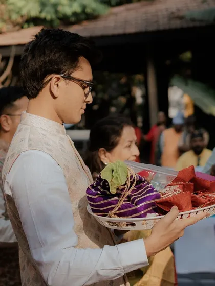 A family member carrying a tray of gifts during the Bhaat ceremony.