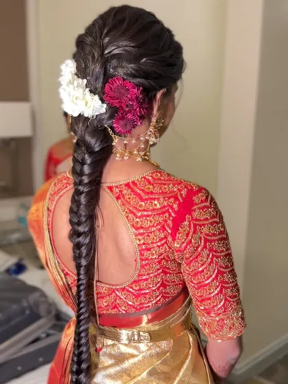 A still image of the beautiful fishtail braid with red and white flowers, showing the texture and color combination.