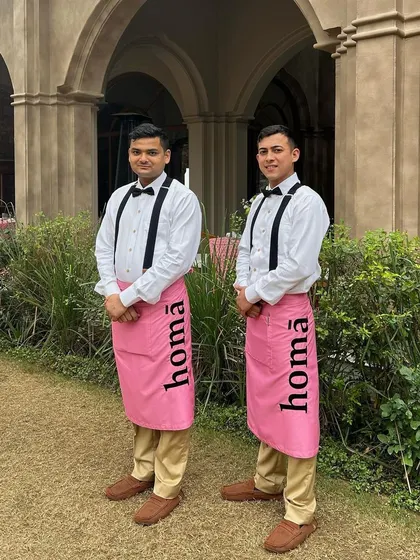 Our professional service staff in their signature pink Homā aprons, ready to welcome guests at a luxury event at Six Senses Fort Barwara.