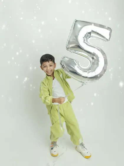 So much energy and fun! The birthday boy is having a great time playing with his giant number five balloon.