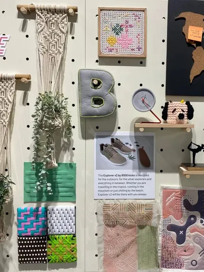 A material board for the 'Solo Commerce' trend, showcasing our design process. The collection of handcrafted items, plants, and travel-related objects speaks to the versatile and location-independent lifestyle of modern entrepreneurs.