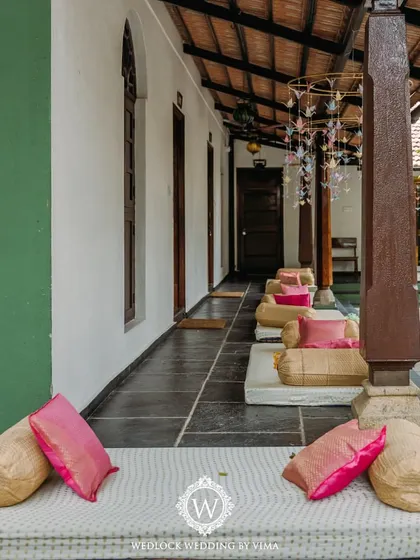 Low-seating arrangements with mattresses and colorful bolsters for a traditional Mehendi ceremony. This creates a relaxed and comfortable atmosphere for guests.
