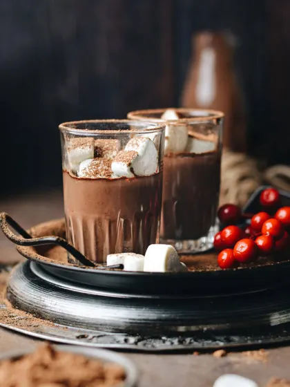 Moody and dark, this shot of hot chocolate with marshmallows feels intimate and cozy, perfect for a cold winter night. The rustic tray and deep tones add to the atmosphere.