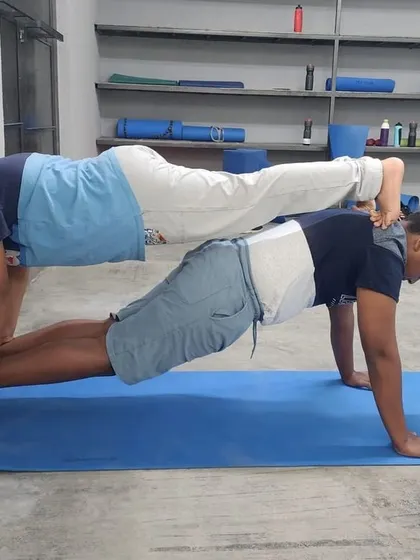 This double plank variation shows the top partner balancing on the base's feet, requiring immense core control from both.